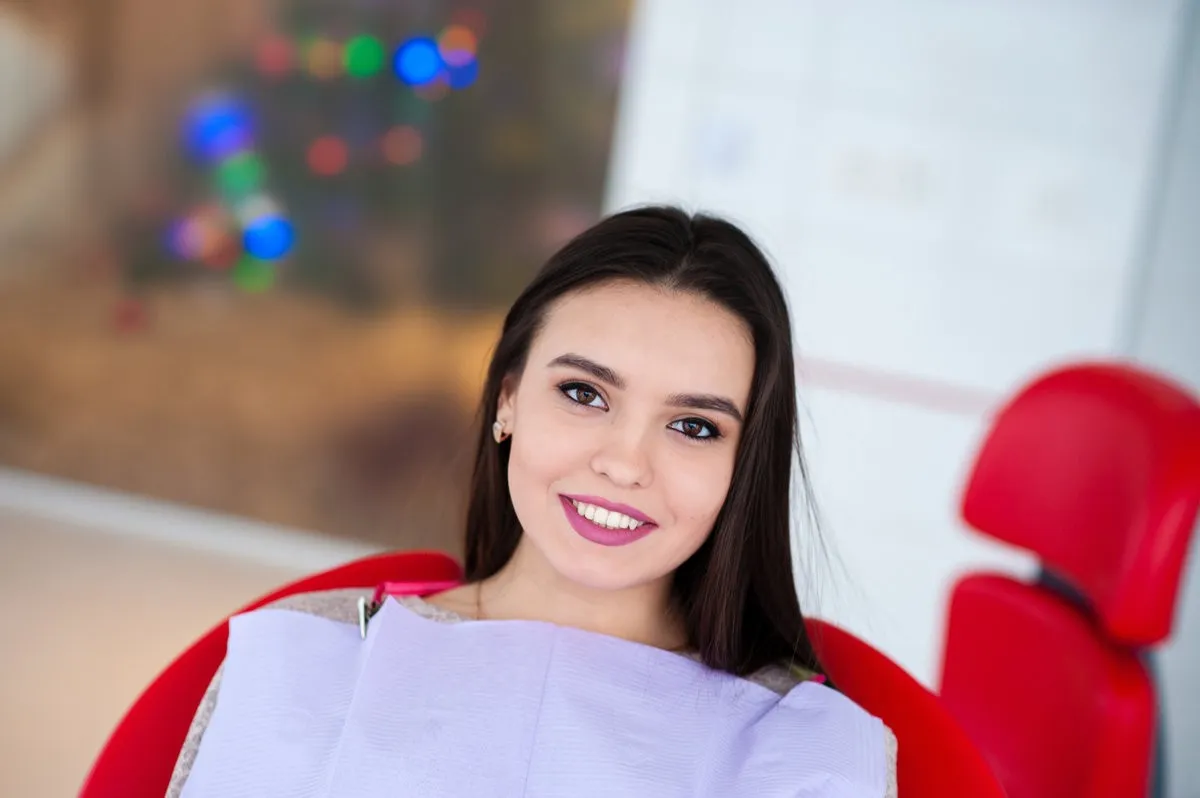 Couple smiling while looking at phone - Sunrise Dental Arts Care Beautiful girl smiling in the dental chair.