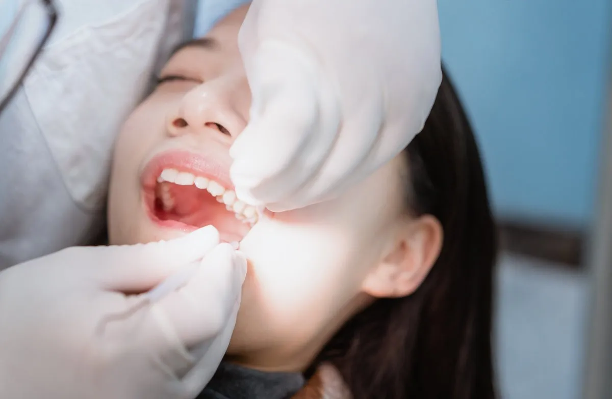 Man pointing at bright smile - Sunrise Dental Arts Care Dental examination with patient in chair