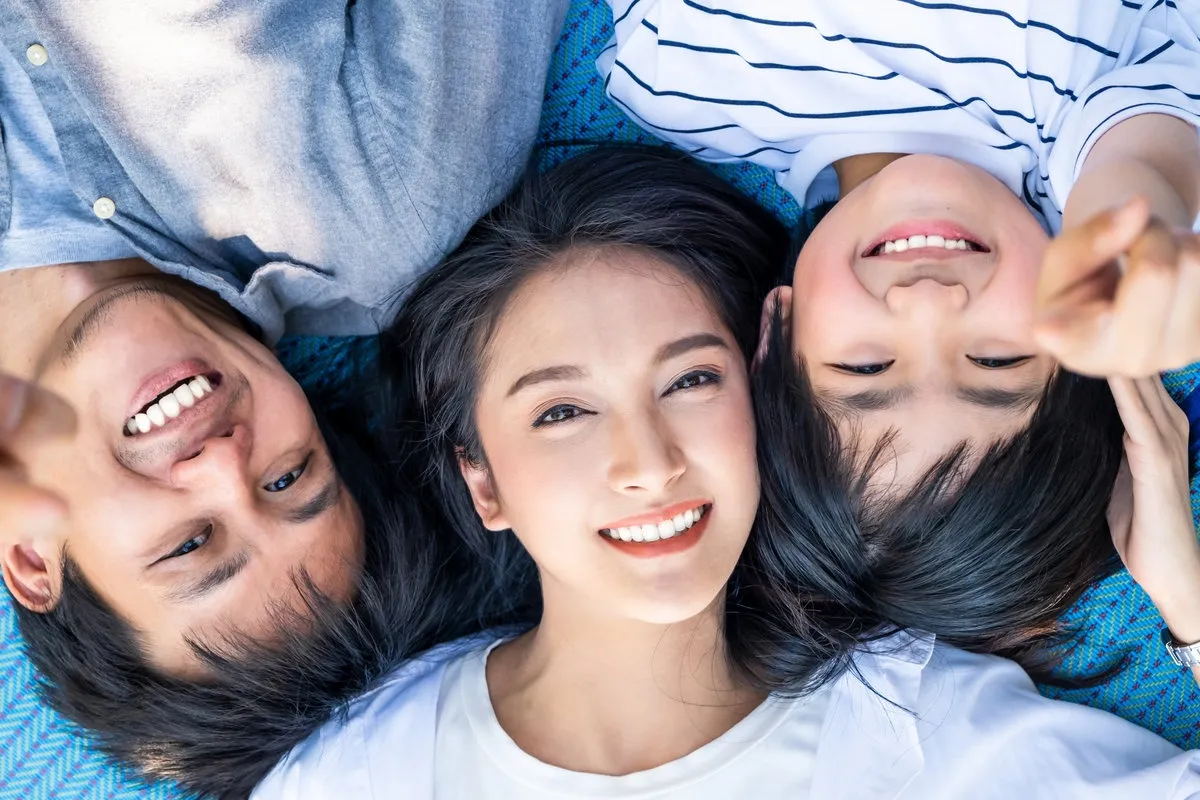 Happy couple smiling outdoors - Sunrise Dental Arts Care Happy family smiling