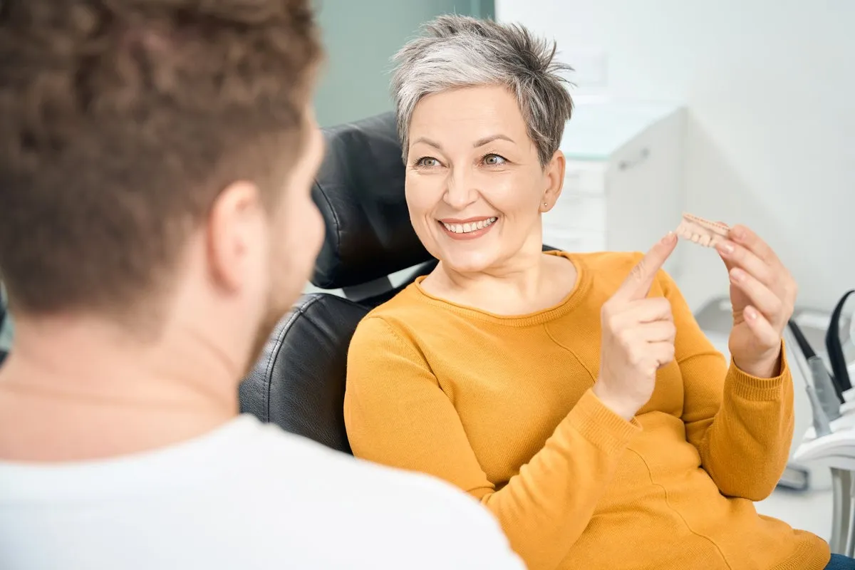 Old woman pointing on her dentures