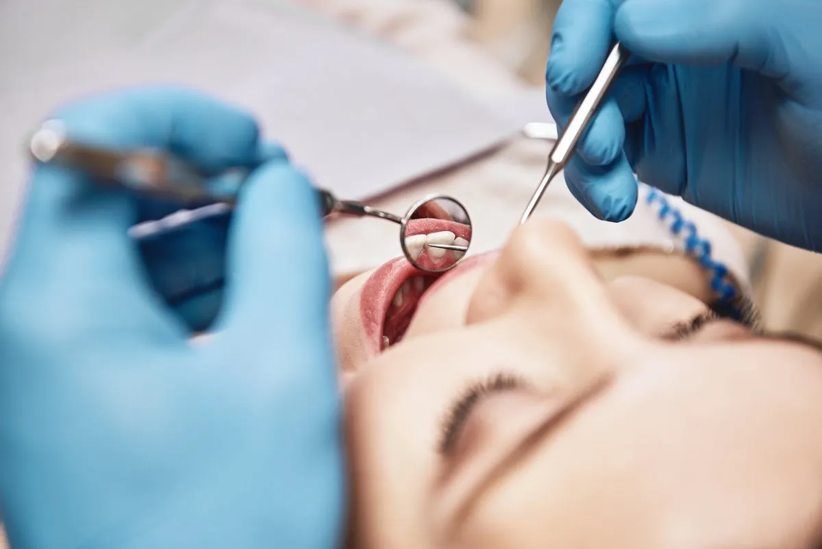 Couple smiling while looking at phone - Sunrise Dental Arts Care Advanced Medicine, Trusted Care. Attractive woman at the dental office. Dentist examining patient's teeth in clinic.