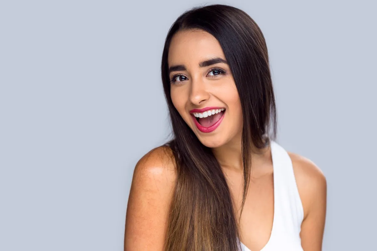 Beautiful hispanic girl proud and confident about her perfect white teeth smile