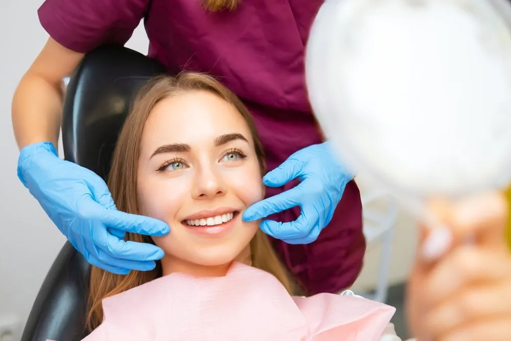 Dentist showing a patient their brighter smile after a professional whitening session