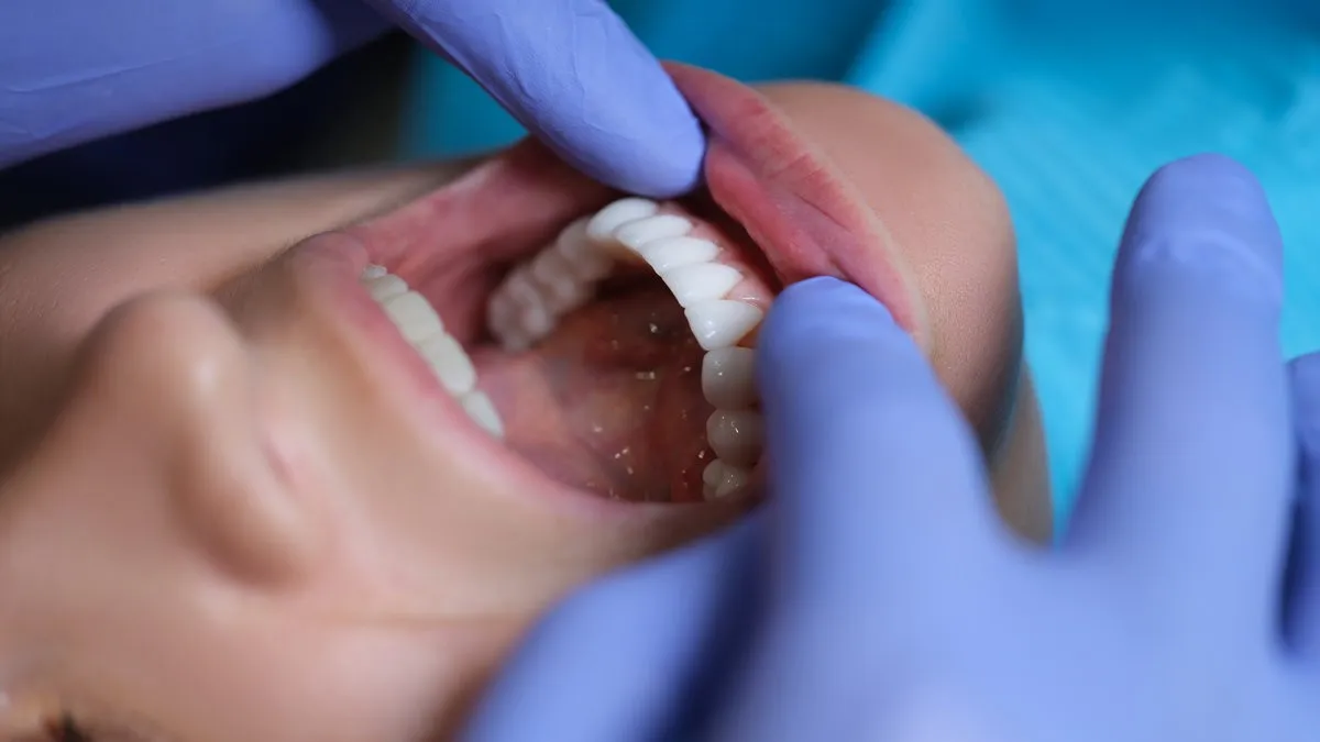 Couple smiling while looking at phone - Sunrise Dental Arts Care Doctor dentist examining patient oral cavity with veneers closeup