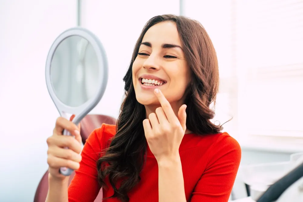 Woman checking her teeth - Dental Implants in Hillcrest