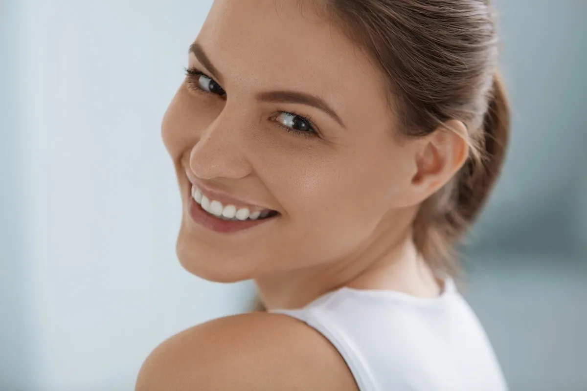 Couple smiling while looking at phone - Sunrise Dental Arts Care Smiling woman face with white teeth smile, clean skin portrait