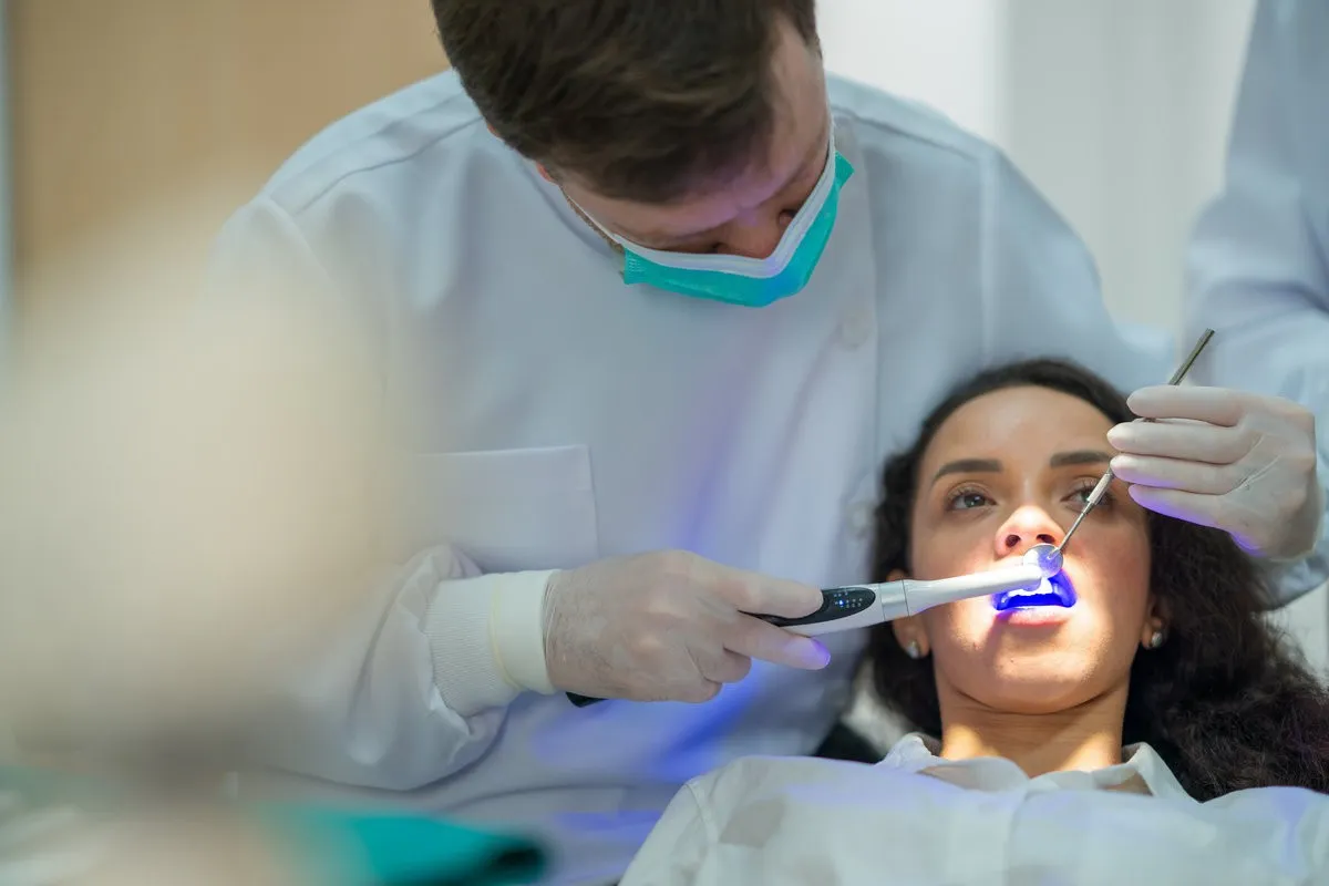 Happy couple smiling outdoors - Sunrise Dental Arts Care The dentist shines ultraviolet light to make the fluoride setting and cover patients' teeth in the dental clinic.