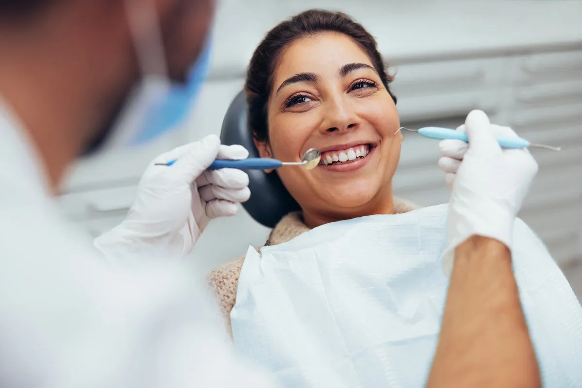 Happy couple smiling outdoors - Sunrise Dental Arts Care Woman having teeth examined at dentist