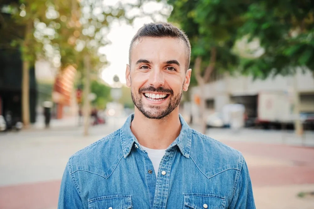 Man with a confident smile standing outdoors in San Diego