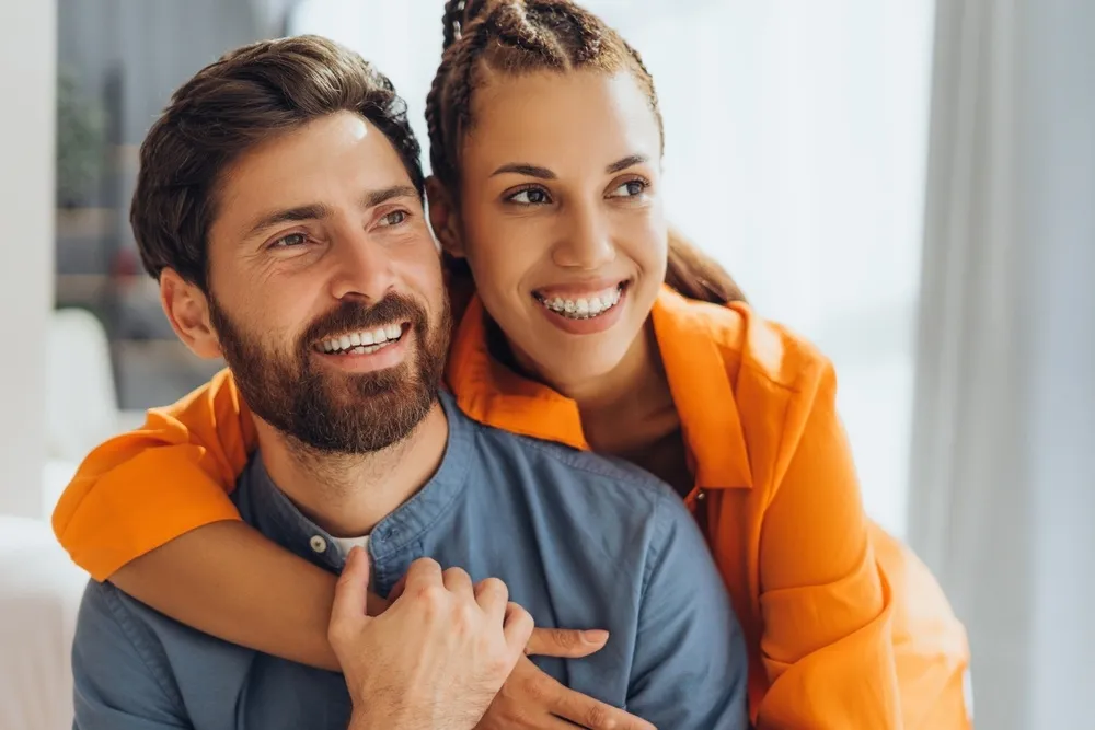 Happy couple smiling together - Dentist in Bankers Hill A joyful couple embracing and smiling warmly, highlighting their bright and healthy smiles - Dentist in Bankers Hill.
