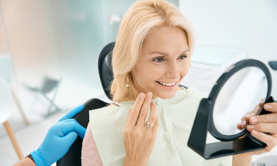 Dentist reviewing dental implant and bridge tooth replacement options with a patient