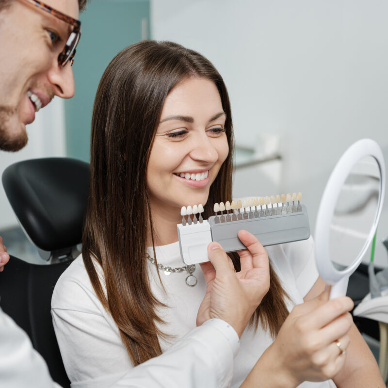 Dentist showing porcelain veneer shade options to a patient
