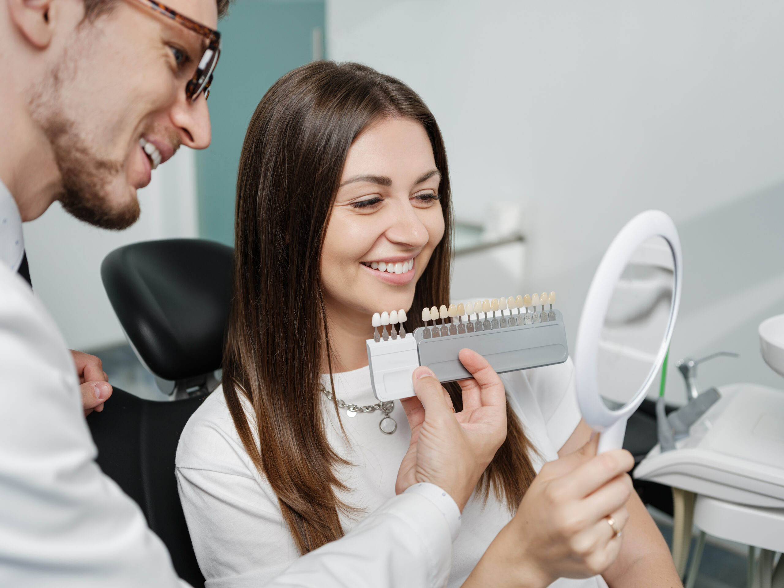 Dentist showing porcelain veneer shade options to a patient
