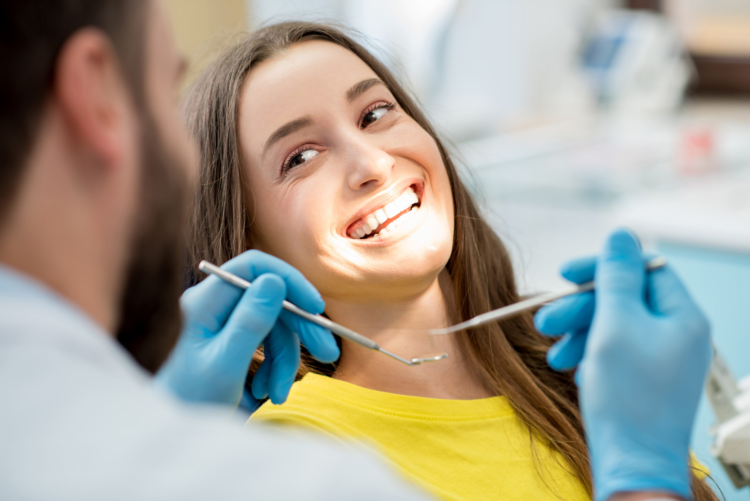 Dental hygienist performing a professional teeth cleaning on a patient at Sunrise Dental Arts